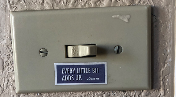 Light switch with a "every little bit adds up" sticker