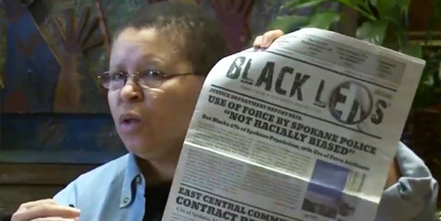 Person holding up Black Lens News paper