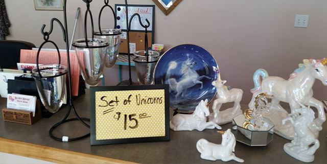 Unicorn figurines next to a sign that says "Set of unicorns - $15"