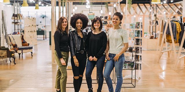 In the retail shop, From Here, four women stand and smile