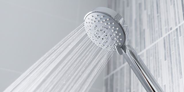 Water running from shower head in modern bathroom