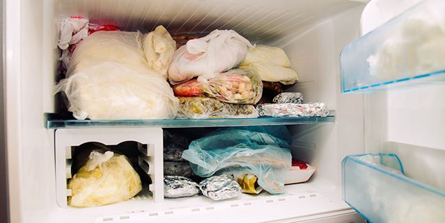 Opened freezer filled with frozen food