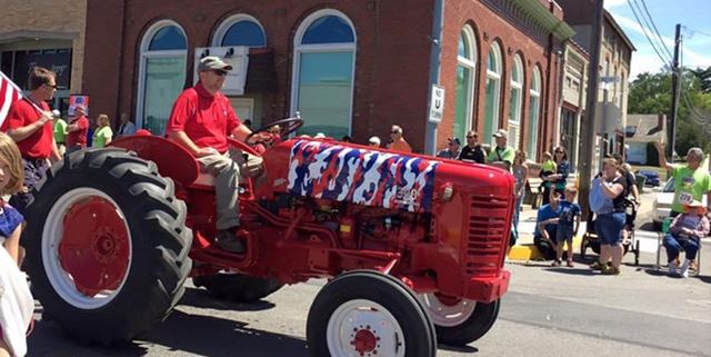 Man riding a tractor in a parade