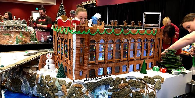An elaborate gingerbread house being built at the Gingerbread Build-Off event