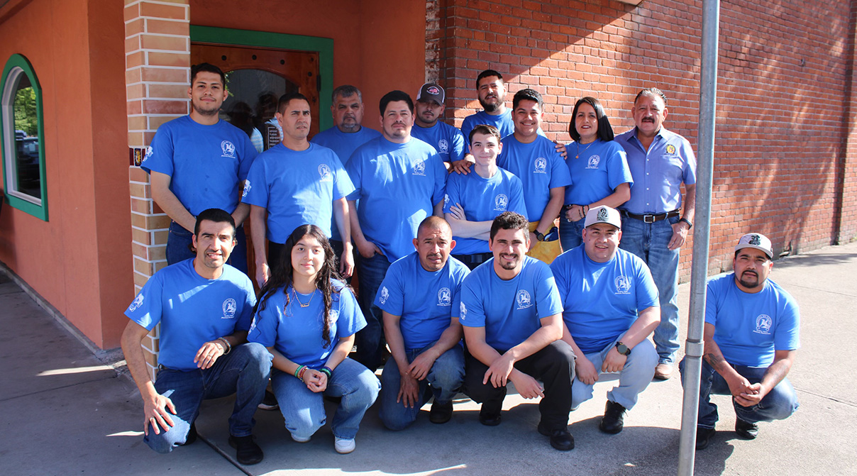 Employees of Fiesta En Jalisco posing outside the restaurant as a group.