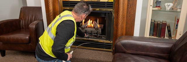 Man lights natural gas fire place.