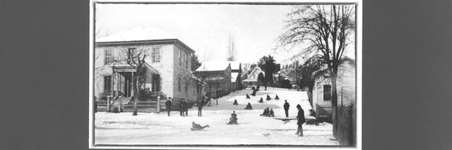 Black and white historic photo of people sledding in Jacksonville, Oregon.