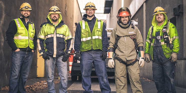 Men in hardhats, yellow safety vests and headlamps