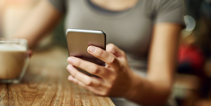 Woman at coffee shop looking at phone
