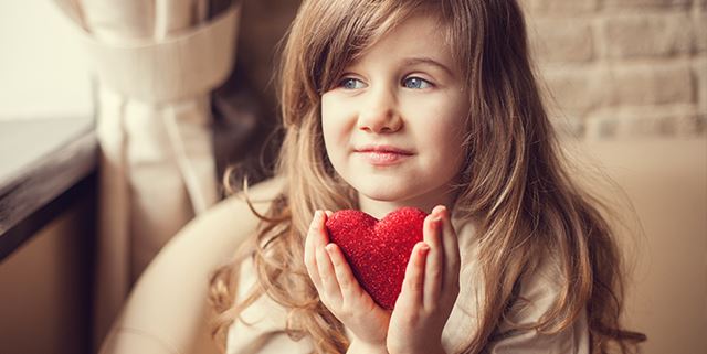 Girl holding sparkly heart in hands