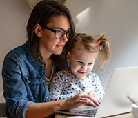 Mother with young daughter on laptop
