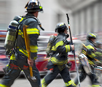 Group of firemen walking quickly towards an emergency.