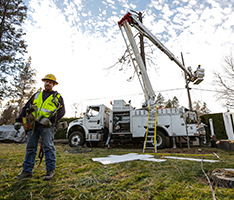 Lineman standing in front of an Avista truck doing work in the background