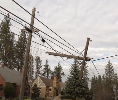 Two power lines outside, one is broken with the top half hanging off.