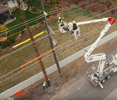 Linemen in bucket truck working on transmission line